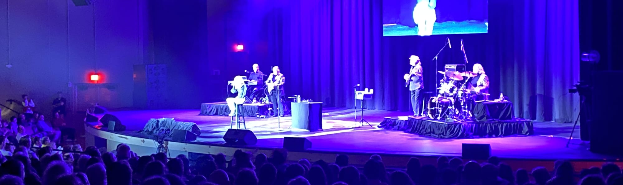 signer on stage in chair washed out by the lights Tucson